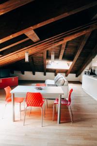 comedor con mesa blanca y sillas rojas en My Loft, en Ferrara
