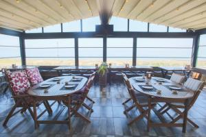ein Esszimmer mit Tischen, Stühlen und Fenstern in der Unterkunft Quantum Hotel in Trabzon