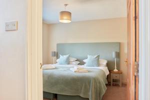 a bedroom with a large bed with a blue headboard at Finest Retreats - Meadow View in Ashbourne