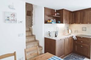 a kitchen with wooden cabinets and a sink at Trullo 100 Passi in Alberobello