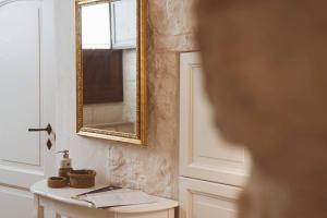 a bathroom with a mirror and a sink at Trullo 100 Passi in Alberobello