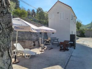 a group of chairs and umbrellas next to a building at Porto Njeguši A1 in Cetinje