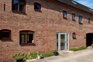 a red brick building with a white door at Finest Retreats - Meadow View in Ashbourne