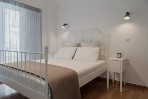 um quarto com uma cama branca e uma janela em Amazing apartment 2 min to Acropolis em Atenas