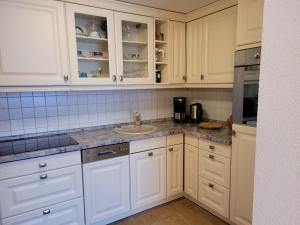 齊諾維茨的住宿－Ferienwohnung Für Zwei，厨房配有白色橱柜和水槽