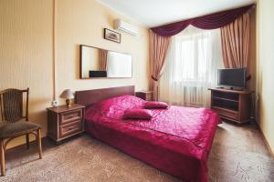 1 dormitorio con cama rosa y TV en Yal Hotel, en Kazán