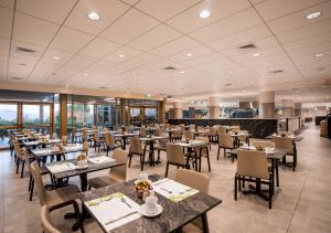 a dining room with tables and chairs in a restaurant at Lavi Kibbutz Hotel in Lavi