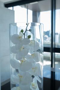 eine Glasvase, gefüllt mit weißen Blumen auf einem Tisch in der Unterkunft The Halyard in Kapstadt