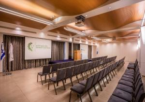 a lecture hall with chairs and a podium at Lavi Kibbutz Hotel in Lavi +31 photos