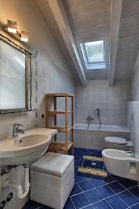 馬爾格拉泰的住宿－Villa Maggie on Lake Como，一间带水槽、浴缸和卫生间的浴室