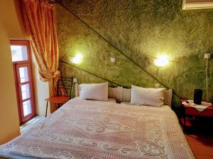 a bedroom with a white bed with a green wall at Caza Latina in Chania Town