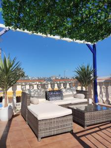 een patio met rieten stoelen en een tafel op een dak bij El Mirador de Torremari - Nudista - Vera playa in Vera