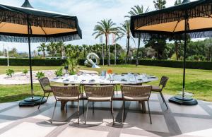 a table and chairs under umbrellas on a patio at Boho Club in Marbella