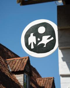 una señal en el lado de un edificio con un hombre y un perro en Le Roitelet - Suite d'hôtes privative, en Montcavrel
