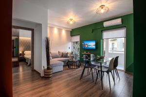 a living room with a couch and a table and chairs at Kentia Modern/Artistic City Apartment in Heraklio Town
