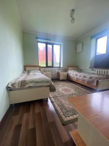 a room with two beds and a table in it at Emir in Dzhetyoguz