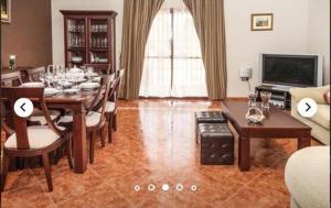 a dining room with a table and chairs and a television at HIDALMAR in Arcos de la Frontera