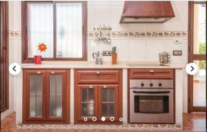 a kitchen with wooden cabinets and a stove top oven at HIDALMAR in Arcos de la Frontera