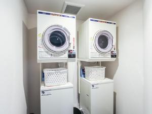 two washing machines in a laundry room with buckets at HOTEL LiVEMAX Kyoto Kamogawamae in Kyoto