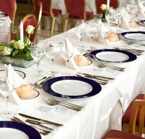 una mesa blanca con platos azules y vasos en ella en Lobios Caldaria Hotel Balneario, en Bubaces