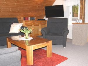 ein Wohnzimmer mit 2 Stühlen und einem Couchtisch in der Unterkunft Ferienwohnung Ilsebill in Husum