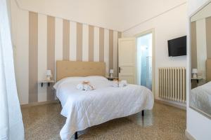 a bedroom with a bed with two stuffed animals on it at GuestHost - Guest House La Baronessa in Ostuni