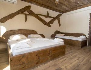 two beds in a room with wooden floors at Complex Starite Kashti in Razvalini Balchikioy