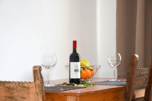 a bottle of wine sitting on a table with two glasses at Litinas Apartments in Agia Marina Nea Kydonias