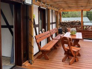 a wooden deck with a wooden bench and a table at Luxury villa in Tinjan with private pool in Harzgerode
