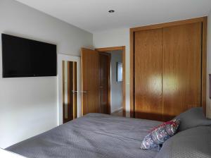 een slaapkamer met een bed en een flatscreen-tv bij Piso en primera linea de Playa en Laxe in Laxe
