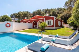 a villa with a swimming pool and a house at Villas Galdana Palms in Cala Galdana