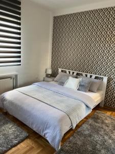 a bedroom with a large bed with a wall at Centar NS2 in Novi Sad +9 photos
