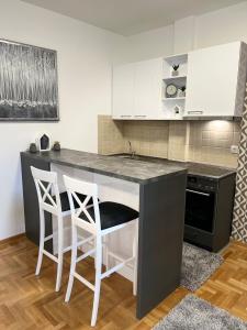 a kitchen with a counter and two stools at Centar NS2 in Novi Sad