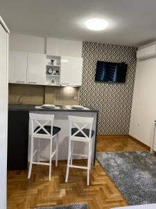 a kitchen with a counter and two stools at Centar NS2 in Novi Sad