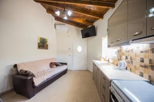 a kitchen with a couch in the middle of a room at Villa Ariadni - Cretan Hospitality in Protória