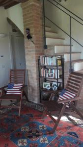 2 sillas en una sala de estar con estantería en Podere La Villa, en Vergelle