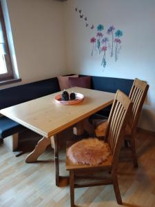 a wooden table and chairs with a plate of food on it at Ferienwohnung Nancy in Jerzens
