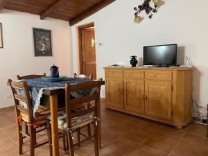 a dining room with a table and a television on a cabinet at Residence Belvedere in Santo Stefano di Sessanio