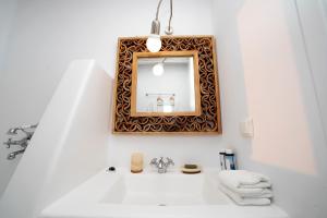baño con lavabo y espejo en la pared en Villa Mandala en Mykonos