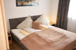 ein Bett mit einer Decke, auf der das Wort lebt in der Unterkunft Apart Schranz in Umhausen