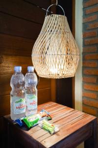 Deux bouteilles d'eau et une lampe sur une table dans l'établissement Katang - Katang Guest House, à Denpasar