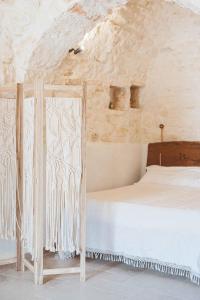 a bedroom with a bed in a stone wall at I trulli di Dioniso - Incipit in Alberobello