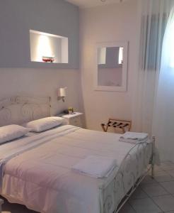 1 dormitorio con 1 cama con sábanas blancas y ventana en Belvedere, en Castro di Lecce