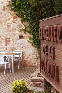 een bord voor een tafel en stoelen op een terras bij El Celler de la Guàrdia in Montserrat