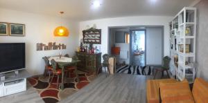 een woonkamer met een televisie en een eetkamer bij Moderno appartamento con splendida vista Alpi in Crans-Montana