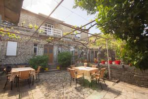 a patio with tables and chairs and a brick building at The Mosaic House - Shtepia me Mozaik in Përmet