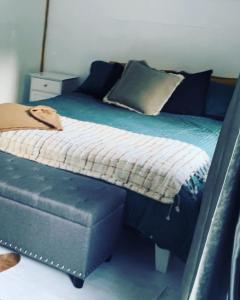 um quarto com uma cama com um sofá e uma roupa de cama com espectáculos em The kauri Tree Pod - Off Grid Experience em Levin