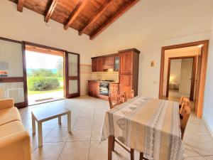 een keuken en eetkamer met een tafel en stoelen bij Saludi&Trigu - Rural Apartments in Iglesias