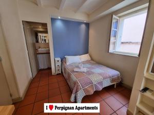 een kleine slaapkamer met een bed en een raam bij I Love Perpignan Apartments 10 in Perpignan