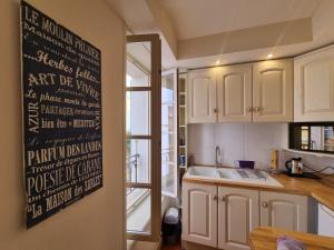 een keuken met witte kasten en een schoolbord aan de muur bij I Love Perpignan Apartments 10 in Perpignan